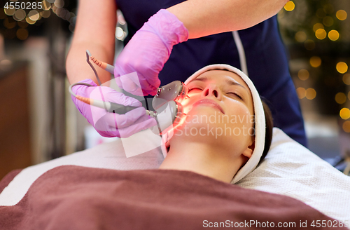 Image of young woman having face microdermabrasion at spa