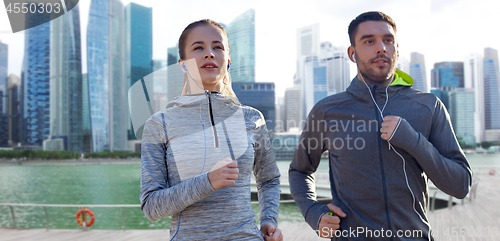 Image of couple with earphones running over singapore 