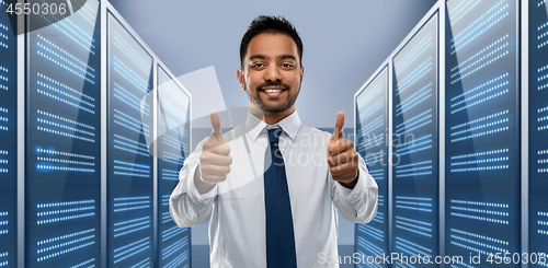 Image of businessman showing thumbs up in server room