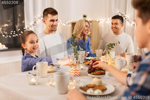 Image of happy family having tea party at home