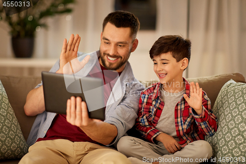 Image of father and son with tablet pc having video chat