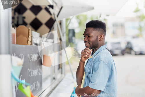 Image of male customer looking at billboard at food truck