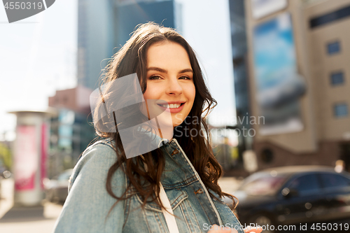 Image of happy smiling young woman on summer city street