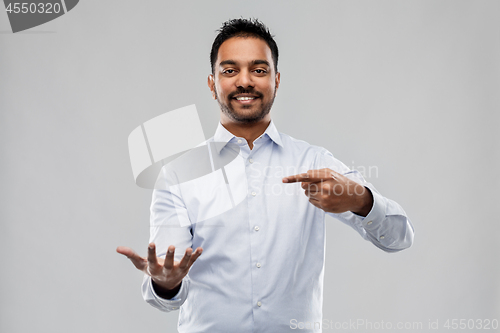 Image of indian businessman holding something invisible