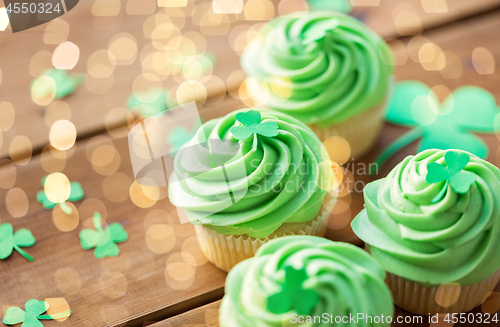 Image of green cupcakes and shamrock on wooden table