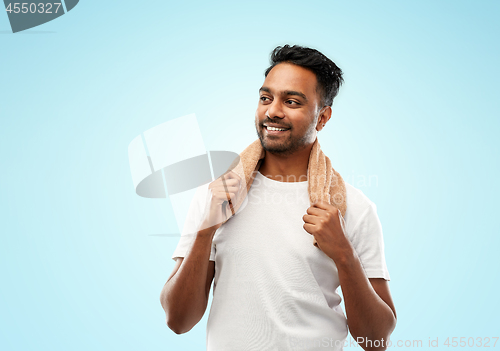 Image of smiling indian man with towel over blue background