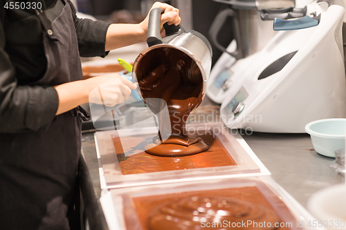 Image of confectioner makes chocolate dessert at sweet-shop