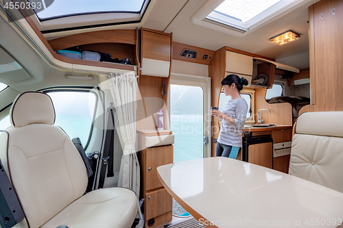 Image of Woman in the interior of a camper RV motorhome with a cup of cof