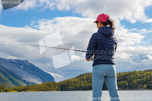 Image of Woman fishing on Fishing rod spinning in Norway.