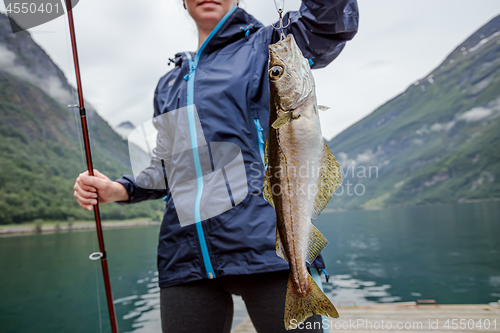 Image of Woman fishing on Fishing rod spinning in Norway.