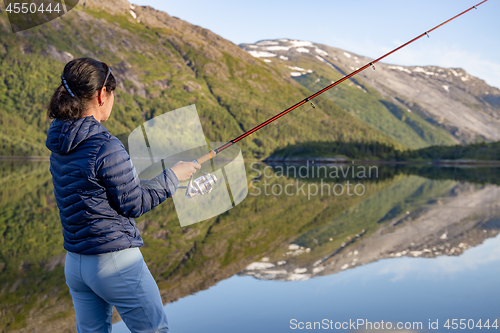 Image of Woman fishing on Fishing rod spinning in Norway.