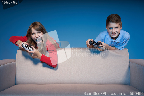 Image of Computer game competition. Gaming concept. Excited girl playing video game with joystick
