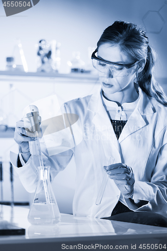 Image of Young scientist pipetting in life science laboratory.