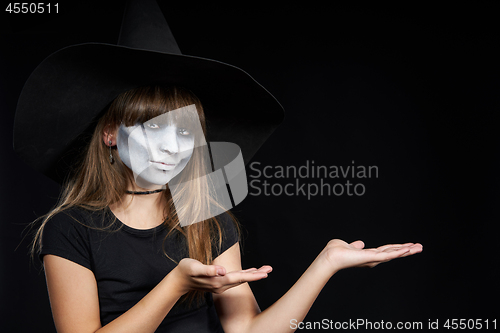 Image of Halloween witch girl looking at camera showing blank copy space on her palms