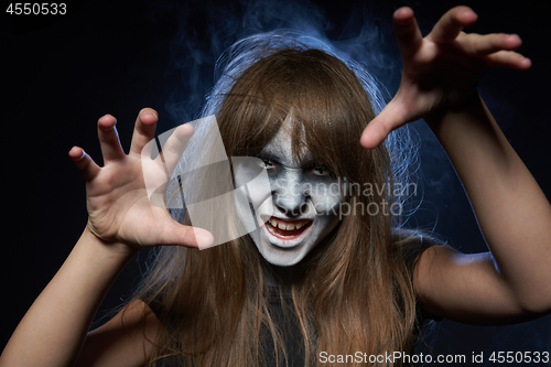 Image of A girl with zombie makeup over dark background with smoke and backlight
