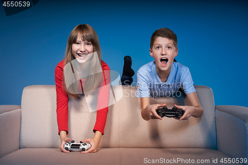 Image of Computer game competition. Gaming concept. Excited girl playing video game with joystick