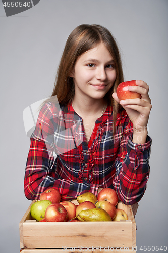 Image of Teen girl with apples and pears in a box