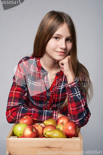 Image of Teen girl with apples and pears in a box