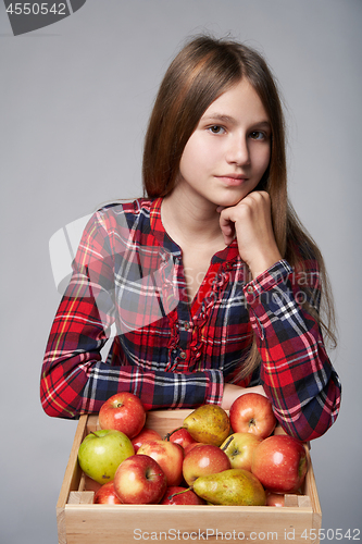 Image of Teen girl with apples and pears in a box