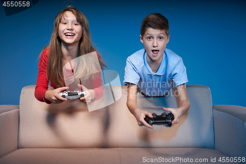 Image of Computer game competition. Gaming concept. Excited girl playing video game with joystick