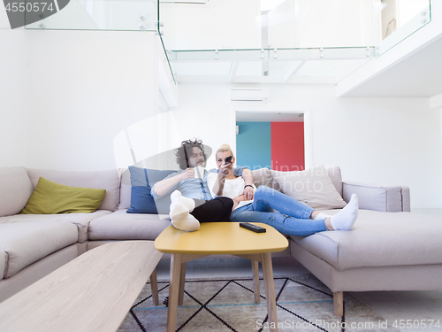 Image of Young couple on the sofa watching television