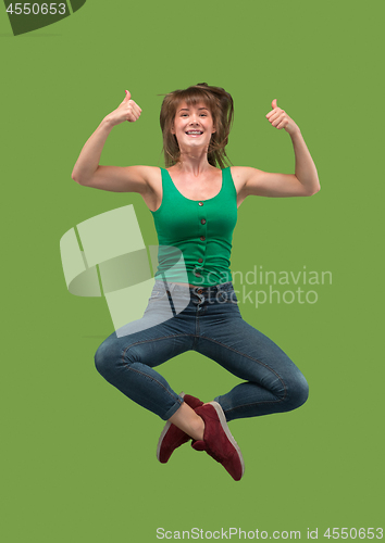 Image of Freedom in moving. Pretty young woman jumping against orange background