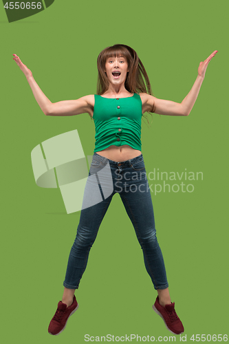 Image of Freedom in moving. Pretty young woman jumping against orange background