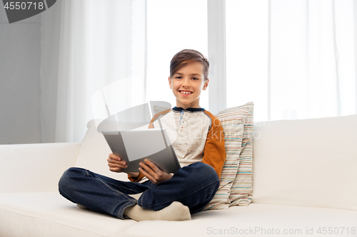 Image of smiling boy with tablet pc computer at home