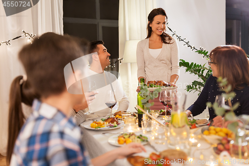 Image of happy family having dinner party at home