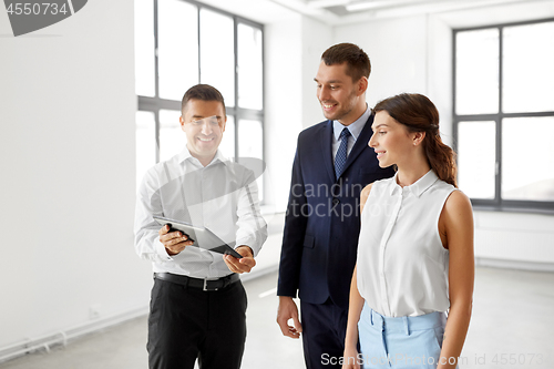 Image of realtor showing tablet pc to customers at office