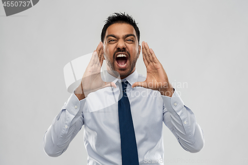 Image of indian businessman screaming over grey