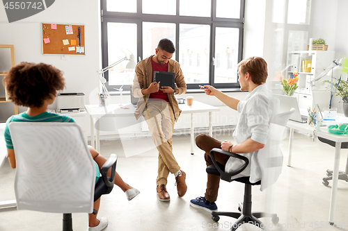 Image of man showing tablet pc to creative team at office