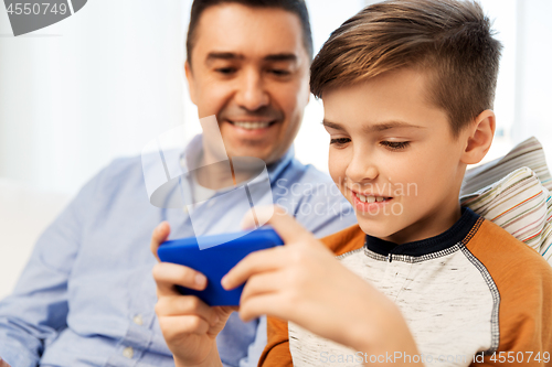 Image of happy father and son with smartphone at home