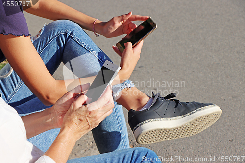 Image of Two young girls watching smart mobile phones