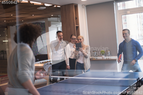 Image of startup business team playing ping pong tennis