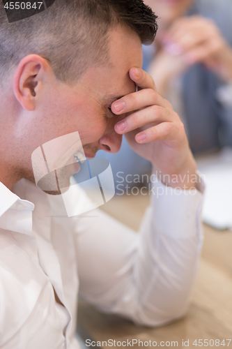 Image of young businessman relaxing at the desk