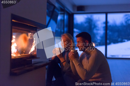 Image of happy couple in front of fireplace