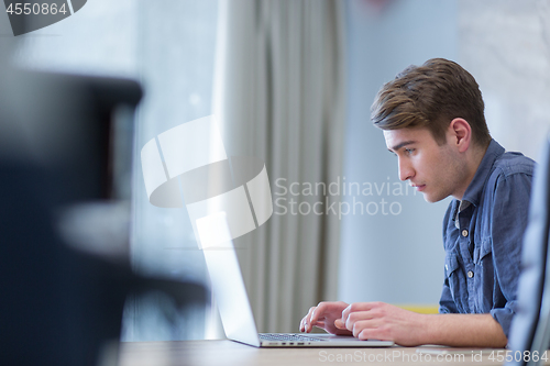 Image of businessman working using a laptop in startup office