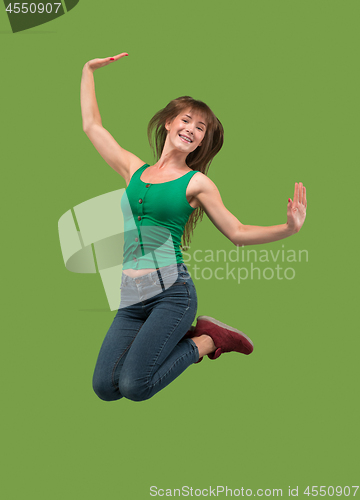 Image of Freedom in moving. Pretty young woman jumping against orange background