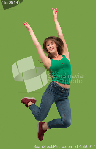 Image of Freedom in moving. Pretty young woman jumping against orange background