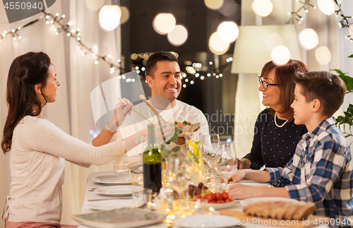 Image of happy family having dinner party at home