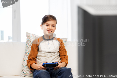 Image of happy boy with gamepad playing video game at home