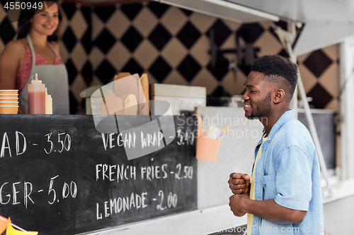 Image of male customer looking at menu board at food truck