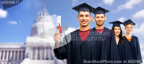 Image of graduates in mortar boards with diploma