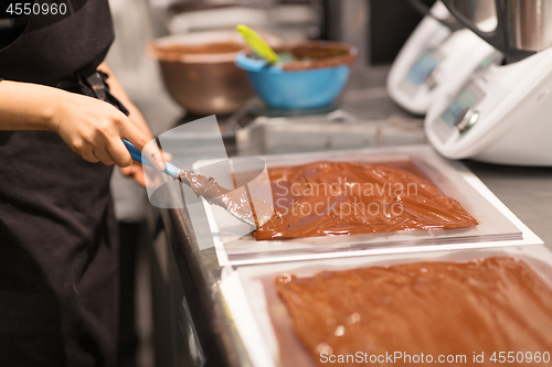 Image of confectioner makes chocolate dessert at sweet-shop