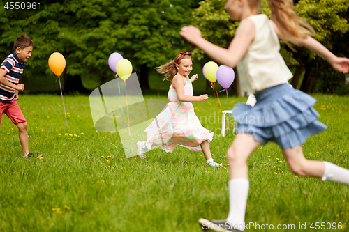 Image of happy kids playing tag game at birthday party