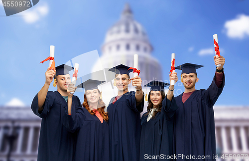 Image of graduates in mortar boards with diplomas