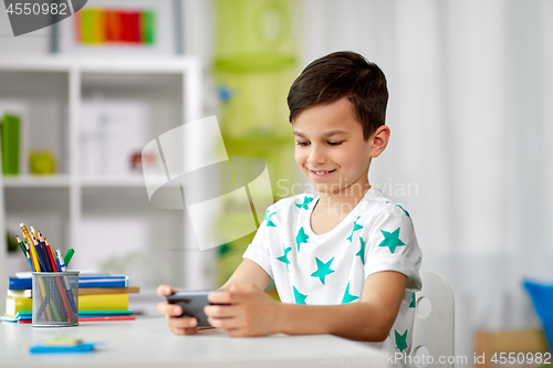 Image of happy boy with smartphone at home