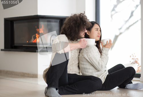 Image of happy multiethnic couple  in front of fireplace