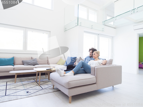 Image of Young couple on the sofa watching television